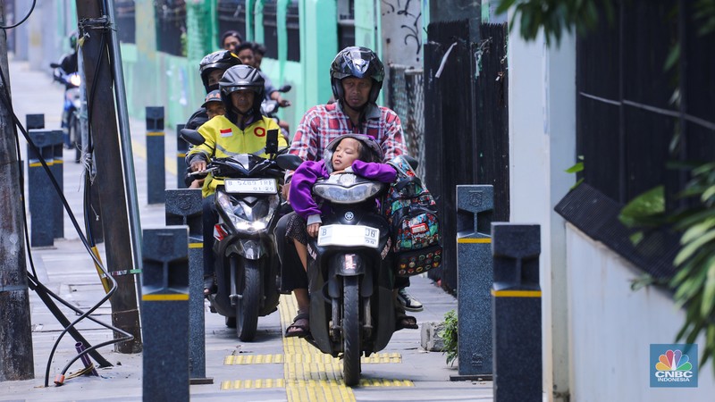 Pengendara sepeda melintasi trotoar jalan di kawasan Matraman, Jakarta, Selasa (5/3/2024). (CNBC Indonesia/Faisal Rahman)