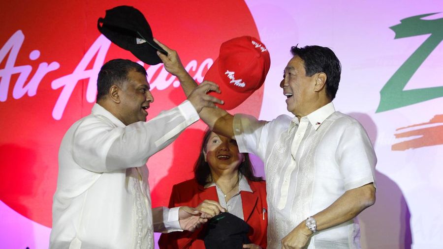 AirAsia founder Tony Fernandes, left, and Zest Airways Inc. President and CEO Alfredo Yao exchange caps after the Signing of Agreement at the financial district of Makati, south of Manila, Philippines on Monday, March 11, 2013. AirAsia, the region's largest budget carrier, expanded its foothold in the Philippines by acquiring 49 percent of local budget carrier Zest Airways. (AP Photo/Aaron Favila)