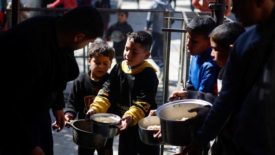 Anak-anak Palestina menunggu untuk menerima makanan yang dimasak oleh dapur amal di tengah kekurangan pasokan makanan, ketika konflik yang sedang berlangsung antara Israel dan kelompok Islam Palestina Hamas berlanjut, di Rafah, di selatan Jalur Gaza, 5 Maret 2024. (REUTERS/Mohammed Salem)