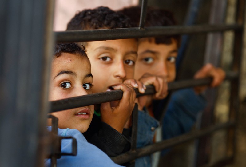 Anak-anak Palestina menunggu untuk menerima makanan yang dimasak oleh dapur amal di tengah kekurangan pasokan makanan, ketika konflik yang sedang berlangsung antara Israel dan kelompok Islam Palestina Hamas berlanjut, di Rafah, di selatan Jalur Gaza, 5 Maret 2024. (REUTERS/Mohammed Salem)