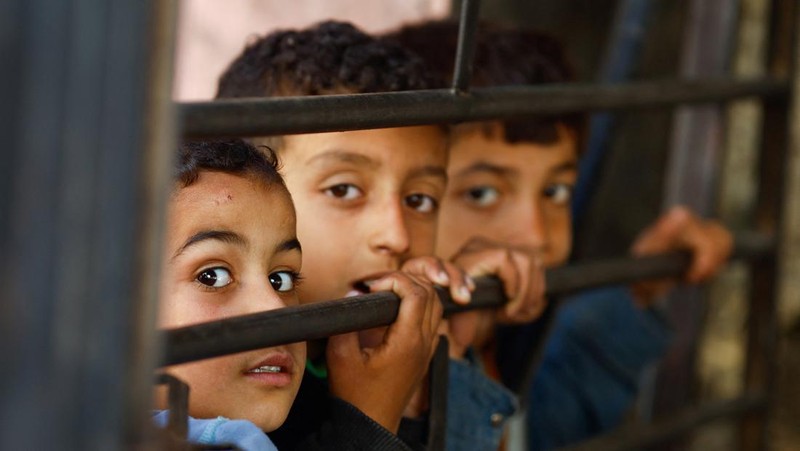 Anak-anak Palestina menunggu untuk menerima makanan yang dimasak oleh dapur amal di tengah kekurangan pasokan makanan, ketika konflik yang sedang berlangsung antara Israel dan kelompok Islam Palestina Hamas berlanjut, di Rafah, di selatan Jalur Gaza, 5 Maret 2024. (REUTERS/Mohammed Salem)