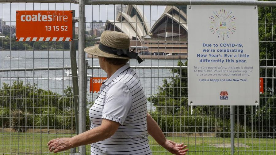Seorang wanita berjalan melewati pagar dekat tepi pelabuhan di Sydney, Australia, Kamis, 31 Desember 2020. (AP Photo/Mark Baker/File Foto)