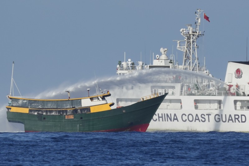 Philippines South China Sea In this image made from video provided by the Philippine Coast Guard, Philippine resupply vessel Unaizah May 4, center, is hit by two Chinese coast guard water canon blasts, causing injuries to multiple crew members as they tried to enter the Second Thomas Shoal, locally known as Ayungin Shoal, in the disputed South China Sea, Tuesday, March 5, 2024. Chinese and Philippine coast guard vessels collided in the disputed South China Sea and multiple Filipino crew members were injured in high-seas confrontations Tuesday as Southeast Asian leaders gathered for a summit that was expected to touch on Beijing's aggression at sea. (Philippine Coast Guard via AP)