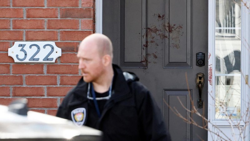 Ottawa Police Service officers surround a home after four children and two adults were found dead inside a neighbouring house in the Ottawa suburb of Barrhaven, Ontario, Canada March 7, 2024.  REUTERS/Blair Gable