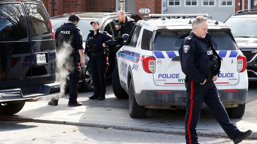 Ottawa Police Service officers surround a home after four children and two adults were found dead inside a neighbouring house in the Ottawa suburb of Barrhaven, Ontario, Canada March 7, 2024.  REUTERS/Blair Gable