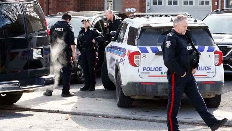 Ottawa Police Service officers surround a home after four children and two adults were found dead inside a neighbouring house in the Ottawa suburb of Barrhaven, Ontario, Canada March 7, 2024.  REUTERS/Blair Gable