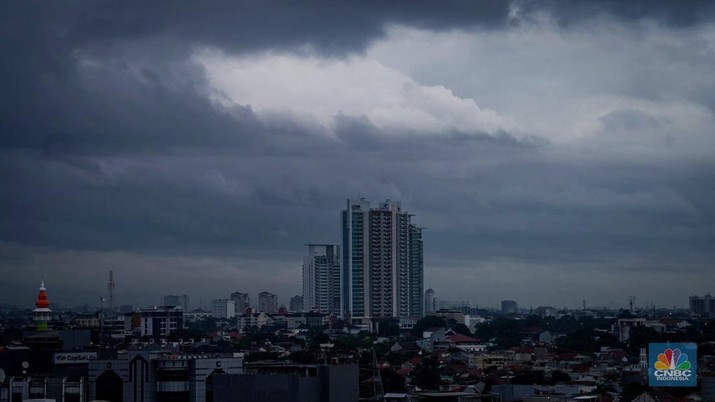 Seseorang melihat suasana langit tertutup awan gelap di Jakarta, Jumat (8/3/2024). (CNBC Indonesia/Tias Budiarto)