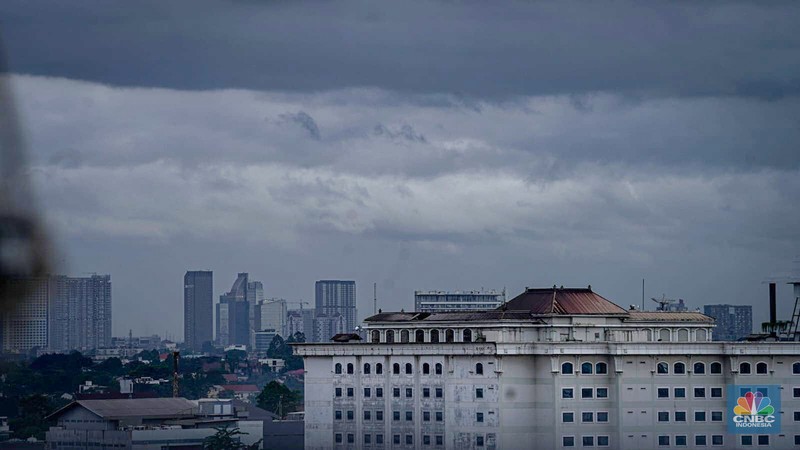 Seseorang melihat suasana langit tertutup awan gelap di Jakarta, Jumat (8/3/2024). (CNBC Indonesia/Tias Budiarto)