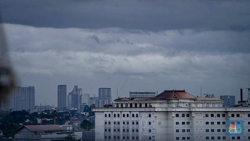 Seseorang melihat suasana langit tertutup awan gelap di Jakarta, Jumat (8/3/2024). (CNBC Indonesia/Tias Budiarto)