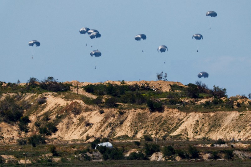 Pesawat militer menjatuhkan paket bantuan untuk warga Palestina di Jalur Gaza, Minggu (10/4/2024). (REUTERS/Amir Cohen)
