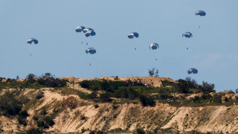 Pesawat militer menjatuhkan paket bantuan untuk warga Palestina di Jalur Gaza, Minggu (10/4/2024). (REUTERS/Amir Cohen)