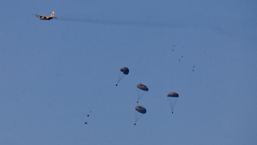 Pesawat militer menjatuhkan paket bantuan untuk warga Palestina di Jalur Gaza, Minggu (10/4/2024). (REUTERS/Amir Cohen)