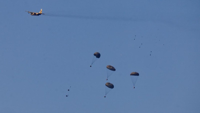Pesawat militer menjatuhkan paket bantuan untuk warga Palestina di Jalur Gaza, Minggu (10/4/2024). (REUTERS/Amir Cohen)