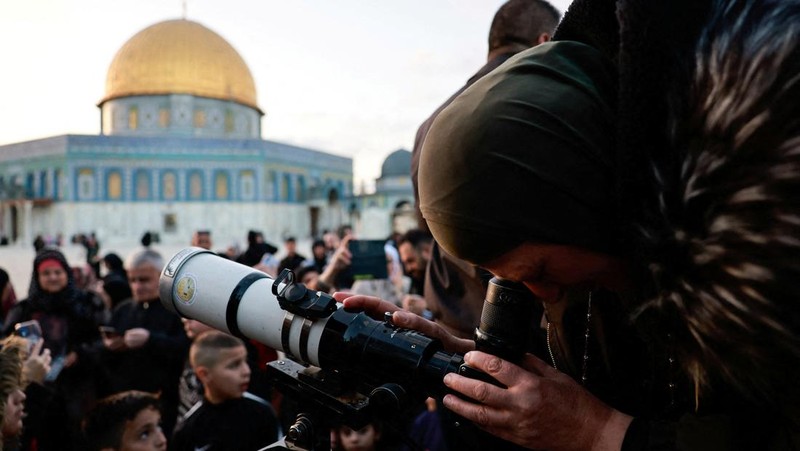 Anggota Masyarakat Astronomi Palestina dan tim Wakaf menggunakan teleskop untuk mencari bulan sabit menjelang bulan suci Ramadhan, di kompleks Al-Aqsa, yang dikenal oleh orang Yahudi sebagai Temple Mount, di Kota Tua Yerusalem 10 Maret 2024. (REUTERS/Ammar Awad)