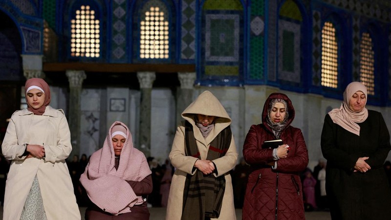 Orang-orang berjalan sebelum mengambil bagian dalam salat malam 'Tarawih' selama bulan suci Ramadhan, di kompleks Al-Aqsa, yang dikenal oleh orang Yahudi sebagai Temple Mount, di Kota Tua Yerusalem 10 Maret 2024. (REUTERS/Ammar Awad)