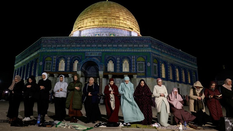 Orang-orang berjalan sebelum mengambil bagian dalam salat malam 'Tarawih' selama bulan suci Ramadhan, di kompleks Al-Aqsa, yang dikenal oleh orang Yahudi sebagai Temple Mount, di Kota Tua Yerusalem 10 Maret 2024. (REUTERS/Ammar Awad)