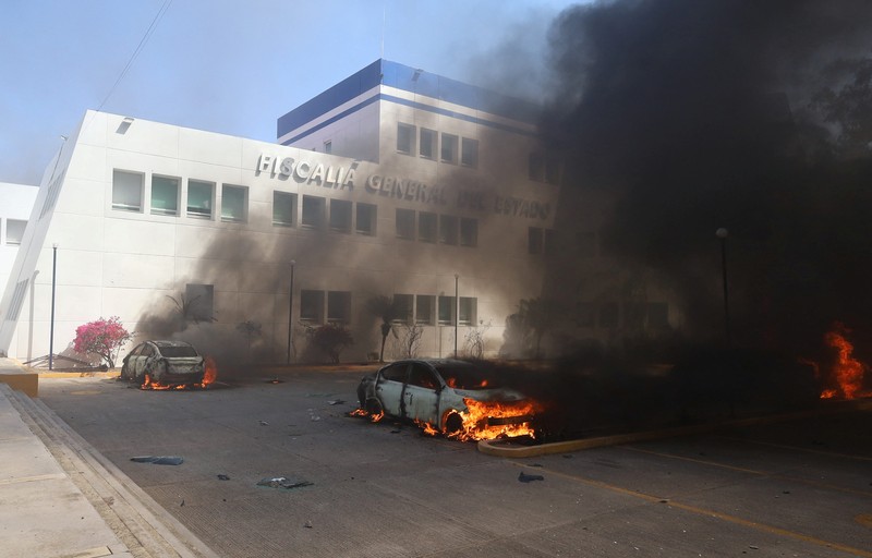 Siswa dari Sekolah Pelatihan Guru Ayotzinapa melakukan protes di luar Kantor Kejaksaan Agung (FGE) di negara bagian Guerrero, setelah Presiden Andres Manuel Lopez Obrador memberi tahu bahwa agen polisi yang diduga membunuh rekan siswa tersebut minggu lalu melarikan diri dari penahanannya, di Chilpancingo, Meksiko Maret 12 Agustus 2024. (REUTERS/Oscar Guerrero)