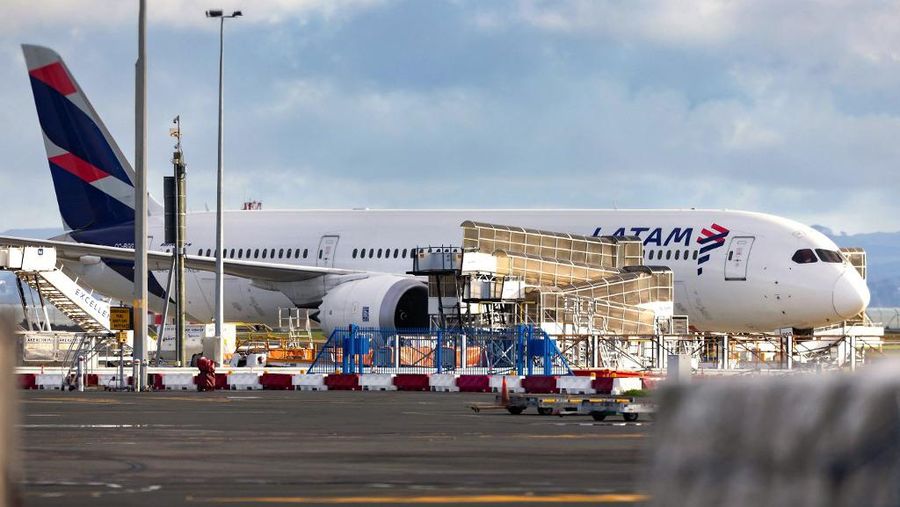Pesawat LATAM Airlines Boeing 787 Dreamliner yang tiba-tiba kehilangan ketinggian di tengah penerbangan sehari sebelumnya, jatuh dengan hebat dan melukai puluhan penumpang yang ketakutan, terlihat di landasan Bandara Internasional Auckland di Auckland pada 12 Maret 2024. (Photo by BRETT PHIBBS / AFP)