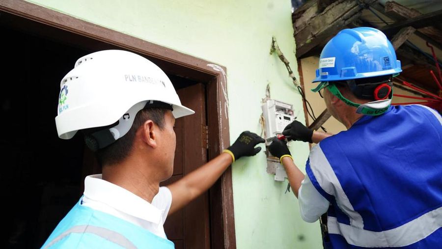 Petugas PLN sedang melakukan penambahan daya di rumah pelanggan. Dengan besar daya yang cukup, pelanggan bisa menikmati listrik yang aman dan nyaman. (Dok. PLN (Persero))