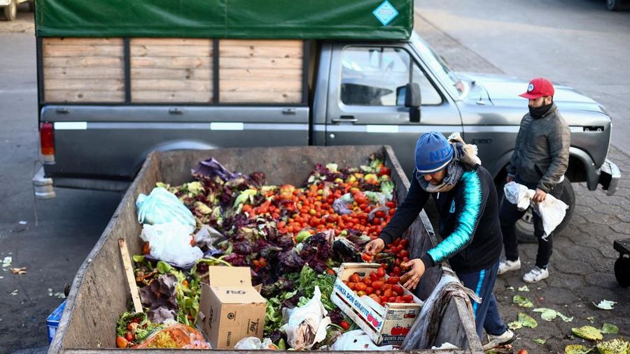 Perempuan mengumpulkan sayuran untuk dibawa pulang setelah dibuang oleh penjual di pasar di pinggiran Buenos Aires, Argentina, Rabu, 10 Januari 2024. (AP Photo/Natacha Pisarenko)