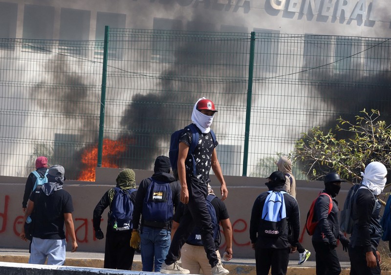 Siswa dari Sekolah Pelatihan Guru Ayotzinapa melakukan protes di luar Kantor Kejaksaan Agung (FGE) di negara bagian Guerrero, setelah Presiden Andres Manuel Lopez Obrador memberi tahu bahwa agen polisi yang diduga membunuh rekan siswa tersebut minggu lalu melarikan diri dari penahanannya, di Chilpancingo, Meksiko Maret 12 Agustus 2024. (REUTERS/Oscar Guerrero)