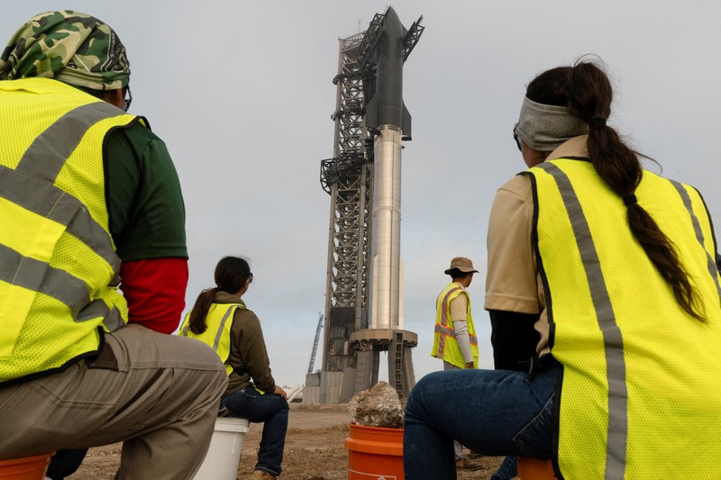 Para pekerja beristirahat sambil memindahkan bebatuan dan puing-puing dari area sekitar saat pesawat luar angkasa Starship generasi berikutnya milik SpaceX yang berada di atas roket Super Heavy. (REUTERS/Cheney Orr) Para pekerja beristirahat sambil memindahkan bebatuan dan puing-puing dari area sekitar saat pesawat luar angkasa Starship generasi berikutnya milik SpaceX yang berada di atas roket Super Heavy. (REUTERS/Cheney Orr)