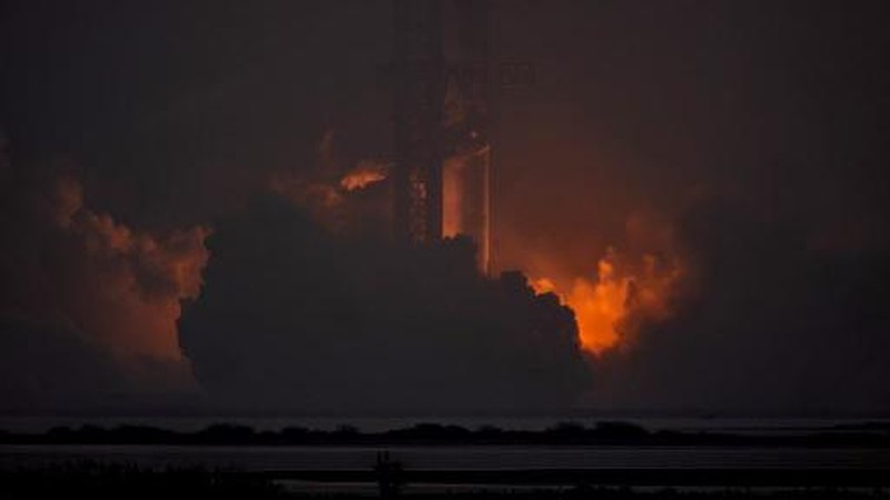 Para pekerja beristirahat sambil memindahkan bebatuan dan puing-puing dari area sekitar saat pesawat luar angkasa Starship generasi berikutnya milik SpaceX yang berada di atas roket Super Heavy. (REUTERS/Cheney Orr)