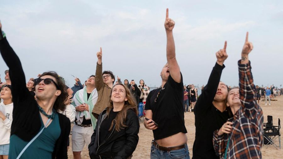 Para pekerja beristirahat sambil memindahkan bebatuan dan puing-puing dari area sekitar saat pesawat luar angkasa Starship generasi berikutnya milik SpaceX yang berada di atas roket Super Heavy. (REUTERS/Cheney Orr)