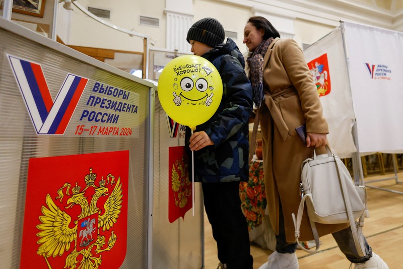 A view shows a screen informing of Russia's presidential election, with the building of Moscow State University (MSU) in the background, in Moscow, Russia March 15, 2024.  REUTERS/Stringer