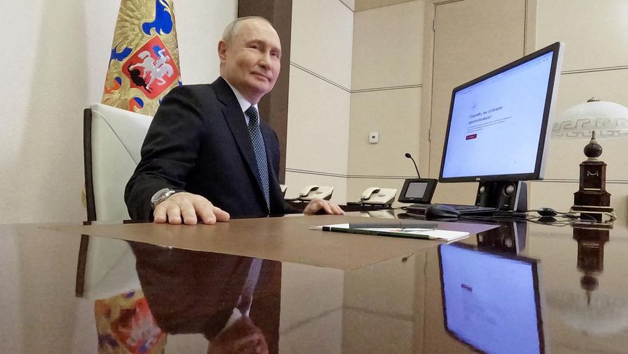 A view shows a screen informing of Russia's presidential election, with the building of Moscow State University (MSU) in the background, in Moscow, Russia March 15, 2024.  REUTERS/Stringer