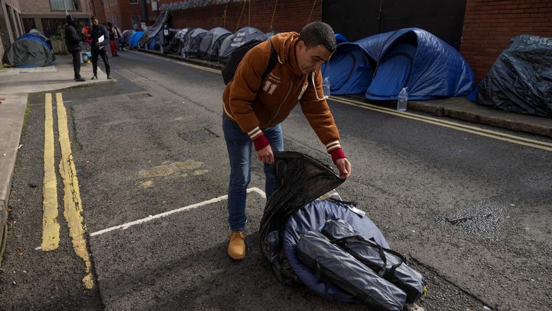 Newly arrived asylum seekers walks past tents belonging to homeless asylum seekers outside the International Protection Office (IPO), where hundreds in search of accommodation have been sleeping on the streets for several months with more arriving every day, in Dublin, Ireland, March 14, 2024. REUTERS/Clodagh Kilcoyne