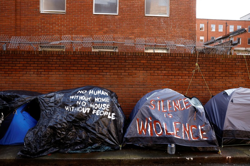 IRELAND-REFUGEES/ Newly arrived asylum seekers walks past tents belonging to homeless asylum seekers outside the International Protection Office (IPO), where hundreds in search of accommodation have been sleeping on the streets for several months with more arriving every day, in Dublin, Ireland, March 14, 2024. REUTERS/Clodagh Kilcoyne