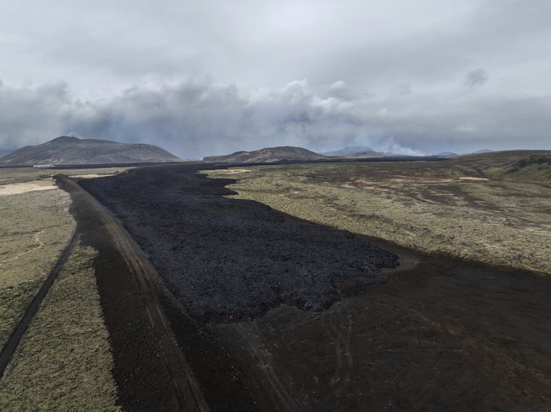 Aliran lava yang melintasi Grindavikurvegur, jalan menuju Grindavik di Islandia, Minggu 17 Maret 2024, sehari setelah letusan gunung berapi. Sistem vulkanik di Semenanjung Reykjanes di barat daya negara itu meletus pada Sabtu malam untuk keempat kalinya dalam tiga bulan. (AP Photo/Marco di Marco)