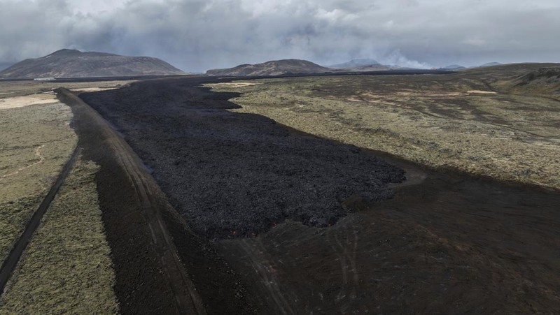 Aliran lava yang melintasi Grindavikurvegur, jalan menuju Grindavik di Islandia, Minggu 17 Maret 2024, sehari setelah letusan gunung berapi. Sistem vulkanik di Semenanjung Reykjanes di barat daya negara itu meletus pada Sabtu malam untuk keempat kalinya dalam tiga bulan. (AP Photo/Marco di Marco)