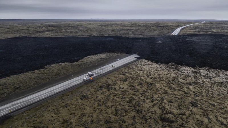 Aliran lava yang melintasi Grindavikurvegur, jalan menuju Grindavik di Islandia, Minggu 17 Maret 2024, sehari setelah letusan gunung berapi. Sistem vulkanik di Semenanjung Reykjanes di barat daya negara itu meletus pada Sabtu malam untuk keempat kalinya dalam tiga bulan. (AP Photo/Marco di Marco)