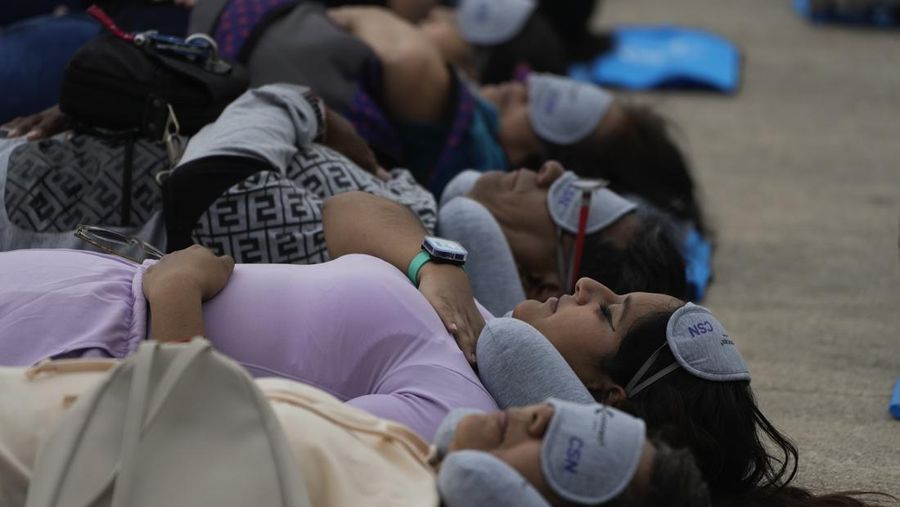 Dilengkapi dengan tikar, masker tidur, dan bantal perjalanan, seorang anak dan seorang wanita tidur siang di dasar Monumen Revolusi yang ikonik, dalam acara yang dijuluki “tidur siang massal,” memperingati Hari Tidur Sedunia, di Mexico City, Jumat, 15 Maret 2024. (AP Photo/Fernando Llano)