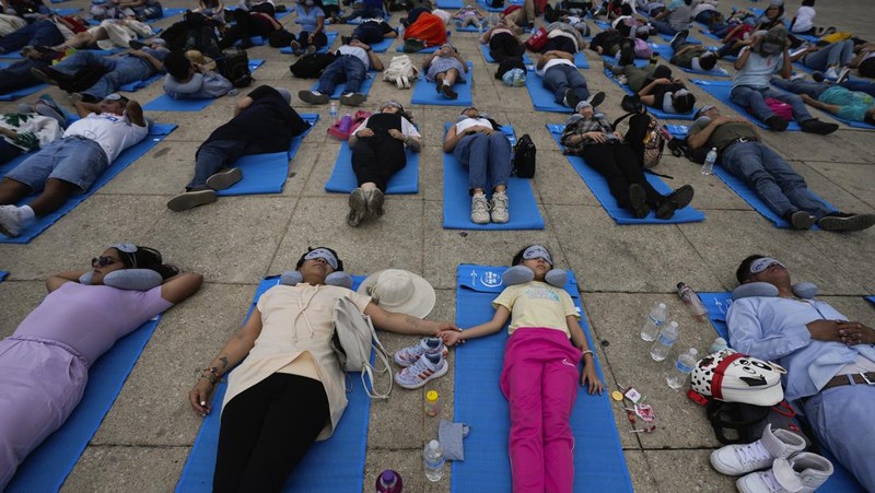Dilengkapi dengan tikar, masker tidur, dan bantal perjalanan, seorang anak dan seorang wanita tidur siang di dasar Monumen Revolusi yang ikonik, dalam acara yang dijuluki “tidur siang massal,” memperingati Hari Tidur Sedunia, di Mexico City, Jumat, 15 Maret 2024. (AP Photo/Fernando Llano)