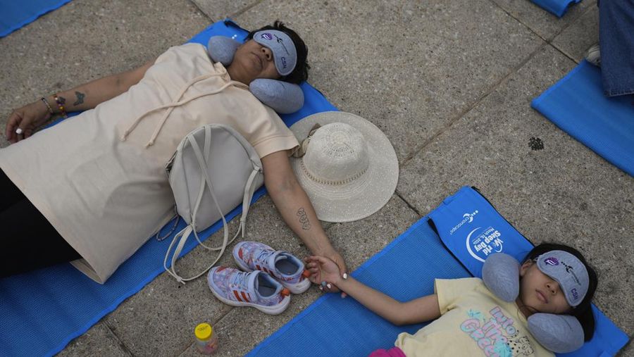 Dilengkapi dengan tikar, masker tidur, dan bantal perjalanan, seorang anak dan seorang wanita tidur siang di dasar Monumen Revolusi yang ikonik, dalam acara yang dijuluki “tidur siang massal,” memperingati Hari Tidur Sedunia, di Mexico City, Jumat, 15 Maret 2024. (AP Photo/Fernando Llano)