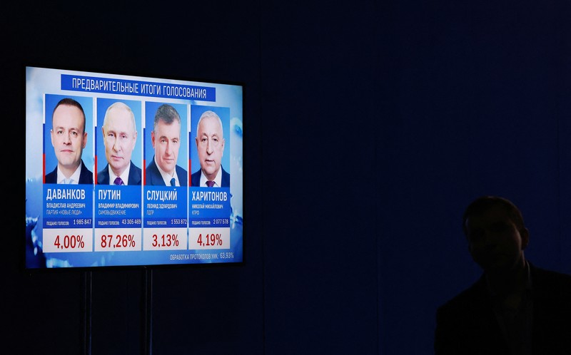 Seorang pria menonton TV yang menyiarkan berita hasil pemilu Presiden petahana dan calon presiden Rusia Vladimir Putin, pada hari terakhir pemilihan presiden di Moskow, Rusia, 17 Maret 2024. (REUTERS/Maxim Shemetov)