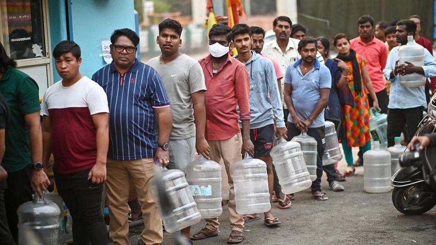 Warga antre air minum di Bengaluru, India, Kamis (14/3/2024). (Photo by Idrees MOHAMMED / AFP)