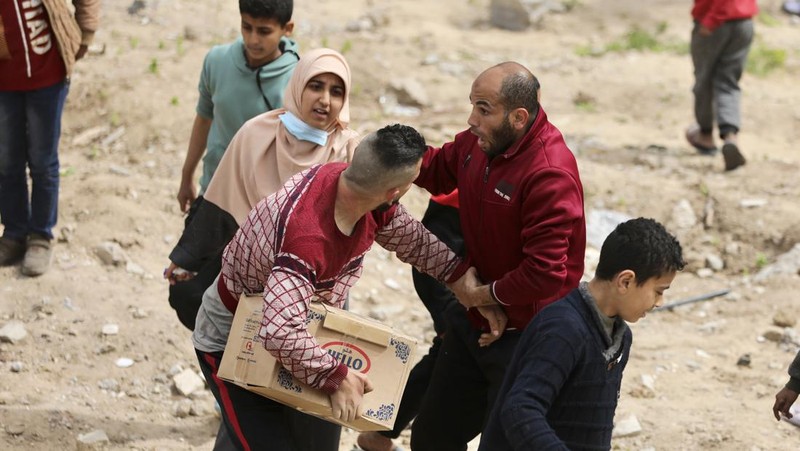 Warga Palestina berkumpul untuk menerima bantuan di luar gudang UNRWA saat warga Gaza menghadapi krisis kelaparan, di tengah konflik yang sedang berlangsung antara Israel dan Hamas, di Kota Gaza 18 Maret 2024. (REUTERS/Mahmoud Issa)