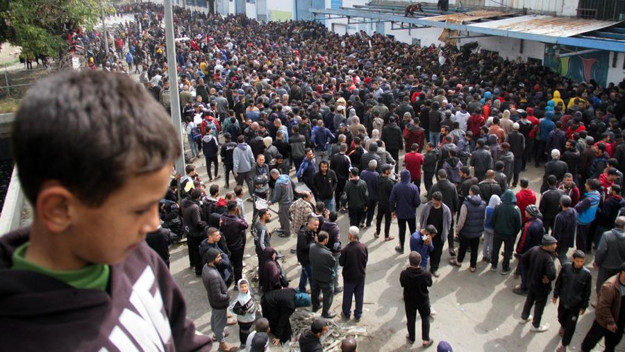 Warga Palestina berkumpul untuk menerima bantuan di luar gudang UNRWA saat warga Gaza menghadapi krisis kelaparan, di tengah konflik yang sedang berlangsung antara Israel dan Hamas, di Kota Gaza 18 Maret 2024. (REUTERS/Mahmoud Issa)
