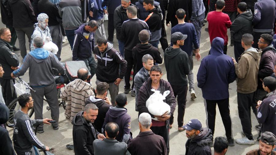 Warga Palestina berkumpul untuk menerima bantuan di luar gudang UNRWA saat warga Gaza menghadapi krisis kelaparan, di tengah konflik yang sedang berlangsung antara Israel dan Hamas, di Kota Gaza 18 Maret 2024. (REUTERS/Mahmoud Issa)