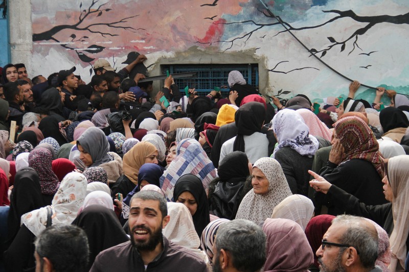 Warga Palestina berkumpul untuk menerima bantuan di luar gudang UNRWA saat warga Gaza menghadapi krisis kelaparan, di tengah konflik yang sedang berlangsung antara Israel dan Hamas, di Kota Gaza 18 Maret 2024. Warga Palestina berkumpul untuk menerima bantuan di luar gudang UNRWA saat warga Gaza menghadapi krisis kelaparan, di tengah konflik yang sedang berlangsung antara Israel dan Hamas, di Kota Gaza 18 Maret 2024. (REUTERS/Mahmoud Issa)