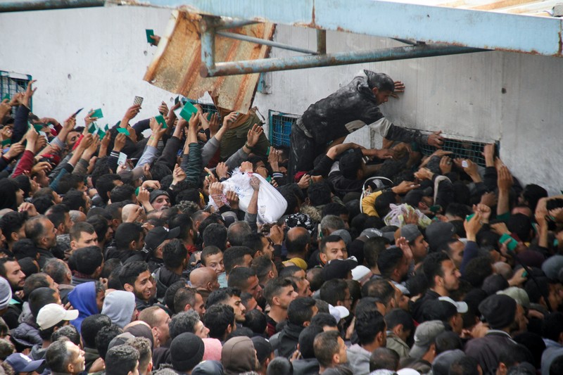 Warga Palestina berkumpul untuk menerima bantuan di luar gudang UNRWA saat warga Gaza menghadapi krisis kelaparan, di tengah konflik yang sedang berlangsung antara Israel dan Hamas, di Kota Gaza 18 Maret 2024. Warga Palestina berkumpul untuk menerima bantuan di luar gudang UNRWA saat warga Gaza menghadapi krisis kelaparan, di tengah konflik yang sedang berlangsung antara Israel dan Hamas, di Kota Gaza 18 Maret 2024. (REUTERS/Mahmoud Issa)