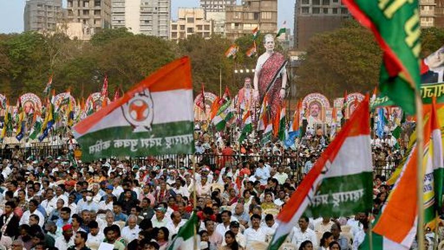 Large cutouts of India's Congress party leaders Sonia Gandhi (C) and her son Rahul Gandhi are displayed behind their supporters during an election campaign rally ahead of the country's upcoming national elections in Mumbai on March 17, 2024. India announced on March 16, that national polls would begin on April 19, with Hindu-nationalist Prime Minister Narendra Modi strongly favoured to win a third term in the world's biggest democracy. (Photo by Indranil MUKHERJEE / AFP)