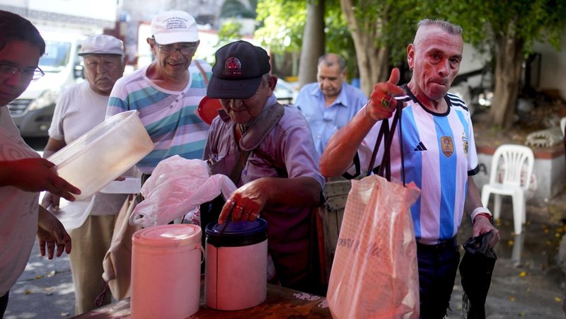 Perempuan mengumpulkan sayuran untuk dibawa pulang setelah dibuang oleh penjual di pasar di pinggiran Buenos Aires, Argentina, Rabu, 10 Januari 2024. (AP Photo/Natacha Pisarenko)