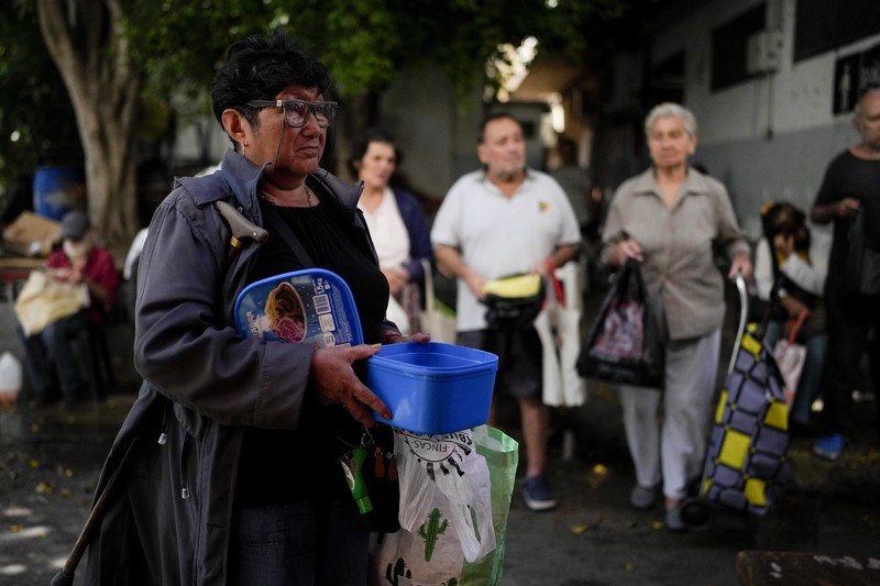 Perempuan mengumpulkan sayuran untuk dibawa pulang setelah dibuang oleh penjual di pasar di pinggiran Buenos Aires, Argentina, Rabu, 10 Januari 2024. (AP Photo/Natacha Pisarenko)