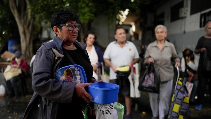 Perempuan mengumpulkan sayuran untuk dibawa pulang setelah dibuang oleh penjual di pasar di pinggiran Buenos Aires, Argentina, Rabu, 10 Januari 2024. (AP Photo/Natacha Pisarenko)