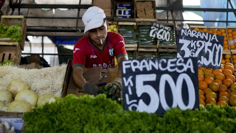 Perempuan mengumpulkan sayuran untuk dibawa pulang setelah dibuang oleh penjual di pasar di pinggiran Buenos Aires, Argentina, Rabu, 10 Januari 2024. (AP Photo/Natacha Pisarenko)